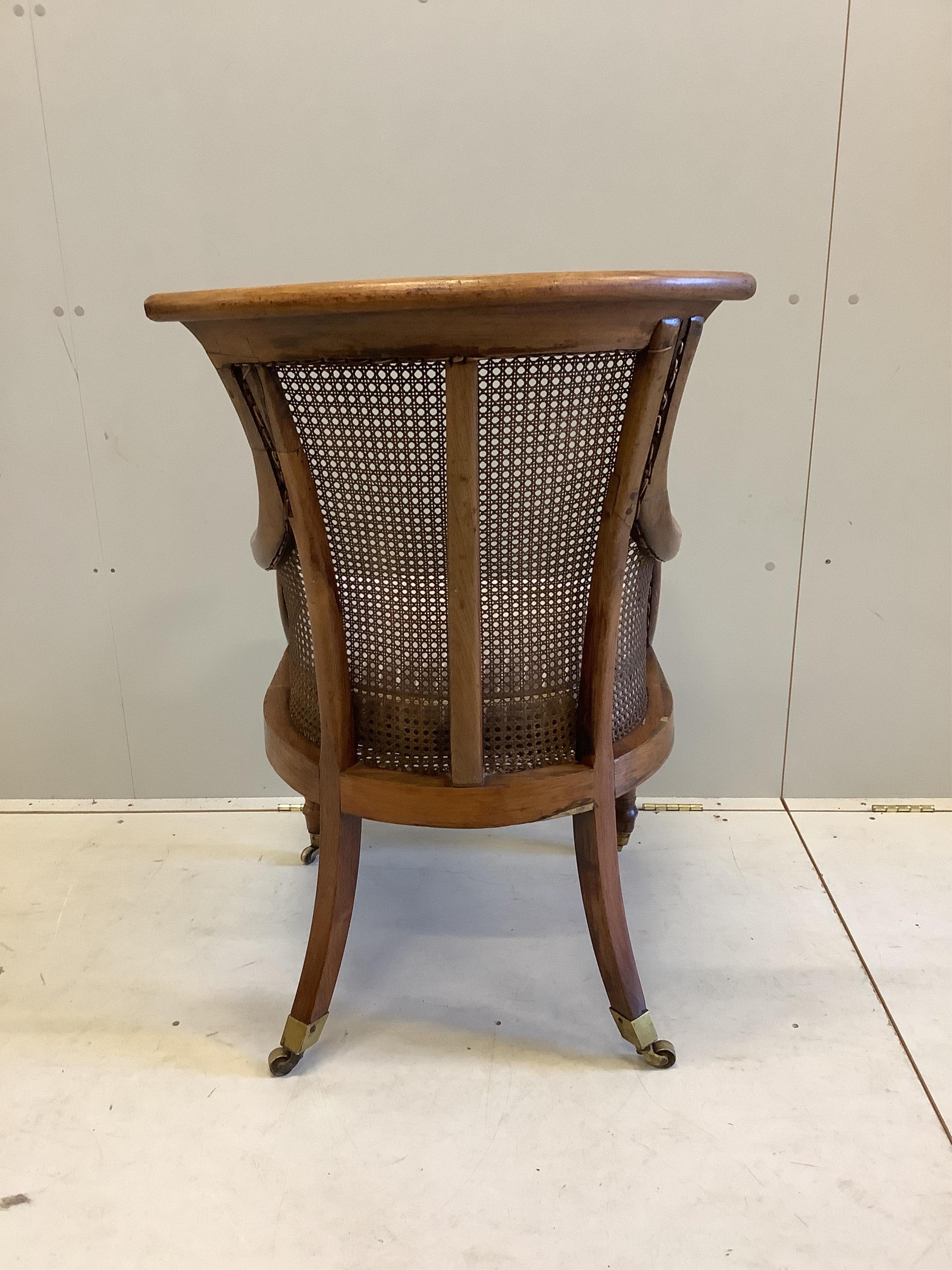 A William IV rosewood bergere library armchair, width 57cm, depth 74cm, height 98cm. Condition - fair, frame faded and has seen much restoration work with repairs to several areas, the cane is good.